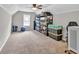 Versatile bonus room with neutral carpet, a ceiling fan, and storage shelves, offering ample space for various activities at 620 Alcovy Springs Dr, Lawrenceville, GA 30045