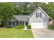 Inviting home featuring a lush green lawn, well-maintained landscaping, and a two-car garage at 620 Alcovy Springs Dr, Lawrenceville, GA 30045