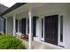 Inviting covered front porch with white columns and a stylish black front door at 620 Alcovy Springs Dr, Lawrenceville, GA 30045