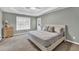 Comfortable primary bedroom with a tray ceiling, neutral decor, and natural light at 620 Alcovy Springs Dr, Lawrenceville, GA 30045