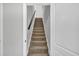 Carpeted staircase with a dark handrail, leading to the upper level of the home, accented by light gray walls at 620 Alcovy Springs Dr, Lawrenceville, GA 30045
