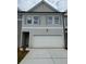 Charming two-story townhome with a gray color scheme, attached garage, and a well-maintained lawn at 1023 Merritt Dr # 100, Villa Rica, GA 30180
