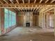 Unfinished living room with window openings, fireplace framing, and exposed beams at 3425 Dr Bramblett Rd, Cumming, GA 30028