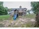 Backyard with a playset, tire swing, and swing set, providing a fun and engaging outdoor space for children at 399 Towler Drs, Loganville, GA 30052
