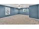 Spacious carpeted basement featuring two windows and a ceiling fan providing ample lighting and ventilation at 399 Towler Drs, Loganville, GA 30052