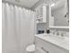 Well-lit bathroom featuring a shower with white curtain and vanity with marble countertop and mirror at 399 Towler Drs, Loganville, GA 30052