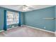 This blue bedroom features a large window and neutral carpeting at 399 Towler Drs, Loganville, GA 30052
