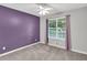 This bedroom features lilac walls, a large window and neutral carpet at 399 Towler Drs, Loganville, GA 30052