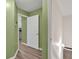 Hallway with green walls, leading to staircase and kitchen with modern appliances and cabinetry at 399 Towler Drs, Loganville, GA 30052