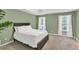 This main bedroom features neutral carpet, two bright windows and a queen bed at 399 Towler Drs, Loganville, GA 30052