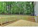 Back deck with wood railing overlooks backyard and bordering woods at 545 Woodrow Dr, Lawrenceville, GA 30043