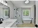 This modern bathroom has a soaking tub and glass shower and a backyard view at 545 Woodrow Dr, Lawrenceville, GA 30043
