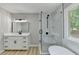 The bathroom features a modern vanity, glass shower and a backyard view at 545 Woodrow Dr, Lawrenceville, GA 30043