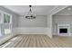 Elegant dining room with stylish chandelier, wainscoting, and a view of the fireplace and backyard at 545 Woodrow Dr, Lawrenceville, GA 30043