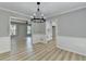 Spacious dining room with stylish lighting, views into the kitchen and living areas, and modern flooring at 545 Woodrow Dr, Lawrenceville, GA 30043