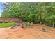 Backyard entertaining space with a stone firepit and decorative landscaping at 155 Edgewater Trl, Canton, GA 30115