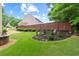 Landscaped backyard with manicured lawn, decorative bushes, and a privacy fence at 155 Edgewater Trl, Canton, GA 30115