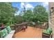 Relaxing outdoor deck with wooden furniture, grilling area, and scenic wooded views for tranquil enjoyment at 155 Edgewater Trl, Canton, GA 30115