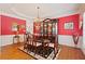 Elegant dining room features a hardwood floor, red walls, and a decorative chandelier at 155 Edgewater Trl, Canton, GA 30115