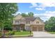 Beautiful two-story home with a well-manicured lawn and mature trees, creating a welcoming curb appeal at 155 Edgewater Trl, Canton, GA 30115