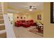 Cozy living room featuring plush red sectional, light wood floors, and a ceiling fan for comfortable living at 155 Edgewater Trl, Canton, GA 30115