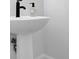 Elegant bathroom features a modern pedestal sink with sleek black faucet at 2139 Kirkham Way, Kennesaw, GA 30152
