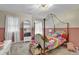 Cozy bedroom features a stylish four-poster bed, unique wallpaper, and ample natural light from the window at 2139 Kirkham Way, Kennesaw, GA 30152