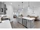 Well-lit kitchen featuring a central island, gray cabinets, and views into the living area at 2139 Kirkham Way, Kennesaw, GA 30152