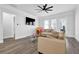 Open-concept living room with sleek flooring, neutral-toned sofas, and a large television at 2139 Kirkham Way, Kennesaw, GA 30152