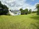 Large grassy backyard view with a two-story home in the background at 23 Jennifer Ln, Rydal, GA 30171