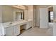 Bright bathroom with double vanity, ample mirror, and a view into the bedroom at 3865 Portico Run Dr, Buford, GA 30519