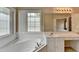 Bright bathroom featuring a tub, window, and double sink vanity with ample lighting at 3865 Portico Run Dr, Buford, GA 30519