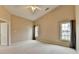 Bright bedroom with neutral walls, carpet, ceiling fan, and windows offering natural light at 3865 Portico Run Dr, Buford, GA 30519
