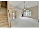 Bright and airy living room with carpeting, adjacent to a staircase and other living spaces at 3865 Portico Run Dr, Buford, GA 30519