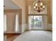 Bright living room with high ceilings and carpeted floors, complemented by an elegant chandelier at 3865 Portico Run Dr, Buford, GA 30519