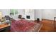 Cozy living room with a gray sofa, fireplace, built-in shelving, and a patterned red rug on hardwood floors at 52 Chaumont Nw Sq, Atlanta, GA 30327