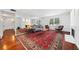 Bright living room with hardwood floors, red patterned rug, and a comfortable seating area at 52 Chaumont Nw Sq, Atlanta, GA 30327