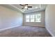 Spacious bedroom with a tray ceiling, a ceiling fan, carpeting, and large windows for natural light at 621 Pineberry Ct, Grayson, GA 30017