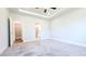 Spacious bedroom with a tray ceiling, carpeting, and access to a walk-in closet and bathroom at 621 Pineberry Ct, Grayson, GA 30017
