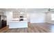 Open-concept kitchen with gray cabinets, stainless steel appliances, a spacious island, and hardwood floors at 621 Pineberry Ct, Grayson, GA 30017