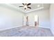 Spacious main bedroom features a ceiling fan, tray ceiling, neutral walls, and plush carpeting at 621 Pineberry Ct, Grayson, GA 30017