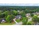 Aerial view of home on a tree-lined street in a residential neighborhood with green spaces and manicured yards at 1253 Oakwood Pl, Loganville, GA 30052