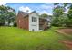 Expansive backyard featuring green grass, an attached garage and elevated deck with stairs at 1253 Oakwood Pl, Loganville, GA 30052