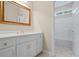 Well-lit bathroom featuring a vanity with gold hardware, a tub/shower and a framed mirror at 1253 Oakwood Pl, Loganville, GA 30052