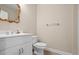 Cozy half-bathroom with pedestal sink, modern toilet, and a beautiful, decorative mirror at 1253 Oakwood Pl, Loganville, GA 30052