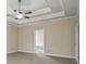 Primary bedroom boasts a tray ceiling, ceiling fan, and ensuite bath at 1253 Oakwood Pl, Loganville, GA 30052