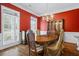 Formal dining room featuring red walls, hardwood floors, and a decorative light fixture at 1253 Oakwood Pl, Loganville, GA 30052