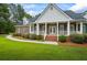 Stately brick home features a covered front porch with columns and professionally landscaped front yard at 1253 Oakwood Pl, Loganville, GA 30052