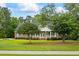 Charming brick home with a welcoming front porch and well-manicured lawn and mature trees at 1253 Oakwood Pl, Loganville, GA 30052