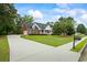 Inviting brick home boasts a long driveway, lush lawn, and charming front porch and manicured shrubs at 1253 Oakwood Pl, Loganville, GA 30052